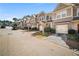 Row of two-story townhomes featuring brick and siding exteriors, individual garages, and professionally landscaped yards at 1094 N Village Dr, Decatur, GA 30032