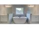 Bright bathroom featuring a large soaking tub with dual vanities and a window at 226 Linford Dr, Locust Grove, GA 30248