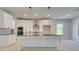 Contemporary kitchen featuring white cabinetry, stainless steel appliances, and a central island with pendant lights at 226 Linford Dr, Locust Grove, GA 30248