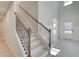 Elegant staircase featuring wood and iron railings, leading to a bright and open entryway with natural light at 226 Linford Dr, Locust Grove, GA 30248