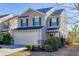 Inviting two-story home featuring a two-car garage, complemented by lush greenery in the front yard at 2650 Richfield Pl, Cumming, GA 30040