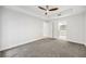 Empty bedroom with plush carpet, tray ceiling, ceiling fan and view of ensuite bathroom at 50 Biscayne Nw Dr # 2111, Atlanta, GA 30309