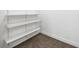 This walk-in closet features built-in white shelves and neutral carpeting at 50 Biscayne Nw Dr # 2111, Atlanta, GA 30309