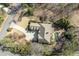 Aerial view of a home with a circular driveway, landscaped grounds, a pool, and a backyard fireplace at 5284 Vernon Springs Trl, Sandy Springs, GA 30327