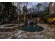 Beautiful backyard featuring custom pool, slide, waterfall, hot tub, stone patio, and manicured landscaping at 5284 Vernon Springs Trl, Sandy Springs, GA 30327