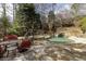 Entertainer's backyard with pool, water slide, hot tub, fireplace, and playhouse with lush landscaping at 5284 Vernon Springs Trl, Sandy Springs, GA 30327