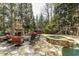 Outdoor entertainment area with stone fireplace, spa, and a playground, nestled among mature trees at 5284 Vernon Springs Trl, Sandy Springs, GA 30327