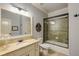 Bathroom featuring marble vanity top, and tiled shower with black framed glass door at 5284 Vernon Springs Trl, Sandy Springs, GA 30327