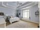 Blue bedroom featuring neutral carpet, light blue walls and a large window at 5284 Vernon Springs Trl, Sandy Springs, GA 30327