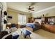 Comfortable bedroom featuring a ceiling fan, a blue themed bed, and a cozy lounging couch at 5284 Vernon Springs Trl, Sandy Springs, GA 30327
