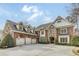 Striking brick home with a three-car garage and detailed stonework for added curb appeal at 5284 Vernon Springs Trl, Sandy Springs, GA 30327