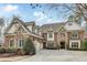 Beautiful two-story brick home featuring a manicured front lawn, driveway, and three-car garage at 5284 Vernon Springs Trl, Sandy Springs, GA 30327