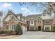Elegant brick home with stone accents, dormers, three-car garage, and well-manicured landscaping at 5284 Vernon Springs Trl, Sandy Springs, GA 30327