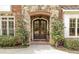 Elegant double front doors with stone and brick accents, enhanced by carefully manicured landscaping at 5284 Vernon Springs Trl, Sandy Springs, GA 30327