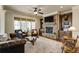 Cozy living room featuring a stone fireplace, built-in bookshelves, and large windows at 5284 Vernon Springs Trl, Sandy Springs, GA 30327