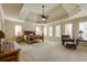 Bright main bedroom with a tray ceiling, carpeted floors, and natural wood furniture at 5284 Vernon Springs Trl, Sandy Springs, GA 30327