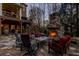 Stone patio with outdoor fireplace, lounge chairs, and lush greenery is perfect for relaxation and entertainment at 5284 Vernon Springs Trl, Sandy Springs, GA 30327