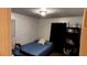Simple bedroom with a blue bedspread, a compact shelf, and a window at 10143 Settlers Grove Ne Rd, Covington, GA 30014