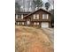 Charming two-story home with a brick and wood exterior, complemented by white trim and an attached garage at 10143 Settlers Grove Ne Rd, Covington, GA 30014