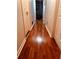 Hallway featuring gleaming wood floors and white trim, leading to multiple rooms at 10143 Settlers Grove Ne Rd, Covington, GA 30014