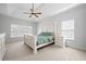 Spacious bedroom featuring a tray ceiling with ceiling fan, and a large bed with two windows at 426 Highcrest Dr, Acworth, GA 30101