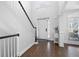 Bright foyer with hardwood floors, staircase, white wainscoting, and view of the front door at 426 Highcrest Dr, Acworth, GA 30101