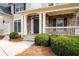 Inviting front porch with stone accents, white columns, decorative lighting and manicured greenery at 426 Highcrest Dr, Acworth, GA 30101