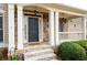 Charming front entrance with a covered porch, stone columns, a stone walkway, and manicured shrubbery at 426 Highcrest Dr, Acworth, GA 30101