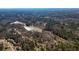 Aerial view of a wooded neighborhood with a pond nearby at 582 Black Forest Run, Douglasville, GA 30134