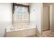 Bright bathroom with a shower, soaking tub, and a window bringing in plenty of light at 582 Black Forest Run, Douglasville, GA 30134