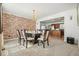 Dining room featuring a modern table, brick accent wall, and views into the kitchen at 582 Black Forest Run, Douglasville, GA 30134