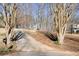 Long driveway leads to a charming two-story home nestled among mature trees, offering privacy and curb appeal at 582 Black Forest Run, Douglasville, GA 30134