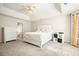 Bright main bedroom featuring carpet, a tray ceiling, and an en suite bathroom at 582 Black Forest Run, Douglasville, GA 30134