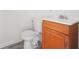 Simple bathroom featuring a toilet, pedestal sink with wood cabinet, and vinyl flooring at 1694 Kenmore Sw St, Atlanta, GA 30311