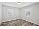 Bedroom with wood-look flooring, neutral walls, closet, and natural light from the windows at 1694 Kenmore Sw St, Atlanta, GA 30311