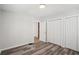 Bedroom featuring neutral walls, wood-look flooring, closet, and doorway to the bathroom at 1694 Kenmore Sw St, Atlanta, GA 30311