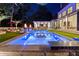 Beautiful backyard pool and outdoor living area with lounge seating, umbrellas, and fire pits at dusk at 3451 Paces Valley Nw Rd, Atlanta, GA 30327