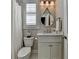 Charming powder room featuring a marble countertop, round decorative mirror, and classic fixtures at 3601 Ridgeway Rd, Duluth, GA 30096