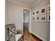 Light-filled hallway with hardwood floors, chair, and a gallery wall of framed Gathering photos at 3601 Ridgeway Rd, Duluth, GA 30096