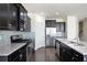 Open kitchen with stainless steel appliances, an island, granite countertops, and dark cabinets at 813 Whittington Sw Pkwy, Marietta, GA 30060