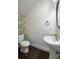 Cozy powder room with pedestal sink, wood look flooring, and framed round mirror at 813 Whittington Sw Pkwy, Marietta, GA 30060
