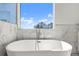 Luxury bathroom showcases a freestanding tub with a floor-mounted faucet and expansive window with views at 145 Hutchinson Ne St, Atlanta, GA 30307