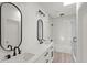 Modern bathroom with double vanity, black fixtures, white cabinets and subway tile shower/tub combo at 145 Hutchinson Ne St, Atlanta, GA 30307