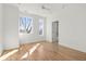 Sunlit bedroom with hardwood floors, two windows, and a doorway to an en-suite bathroom at 145 Hutchinson Ne St, Atlanta, GA 30307