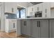 Modern kitchen featuring white cabinets, a gray island, stainless steel appliances, and stylish backsplash at 145 Hutchinson Se St, Atlanta, GA 30307