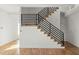 Modern staircase with wood treads and black metal railing in a bright, open entryway at 145 Hutchinson Ne St, Atlanta, GA 30307