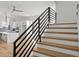 Modern staircase with wood treads and black metal railing, adjacent to the kitchen at 145 Hutchinson Ne St, Atlanta, GA 30307