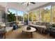 Relaxing sunroom filled with natural light, neutral furnishings, and views of the landscaped yard at 155 Saddleview Run, Atlanta, GA 30350