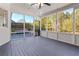 Enclosed sunroom with floor-to-ceiling windows, views of the trees, and a gray painted wood floor at 155 Saddleview Run, Atlanta, GA 30350