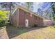 Back of red brick house with green grass and blue skies on a sunny day at 1753 Dodson Sw Dr, Atlanta, GA 30311